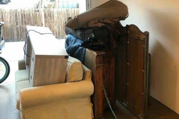 Old furniture and household items in a cluttered garage ready for removal in Winter Haven, FL.